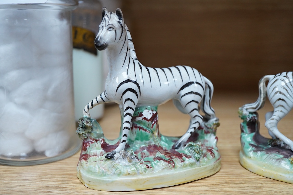 A pair of mid 19th century Staffordshire pottery models of Zebra, 12.5cm high